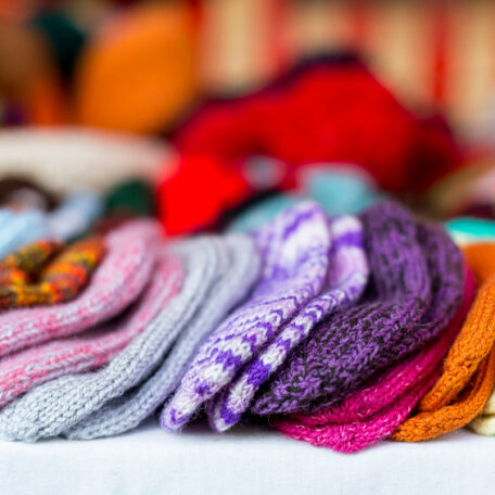 a  row of multicolored hand-knitted baby socks